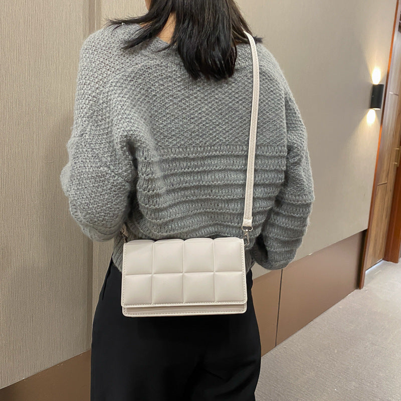 En lille firkantet taske med en skulderrem og crossbody-funktion