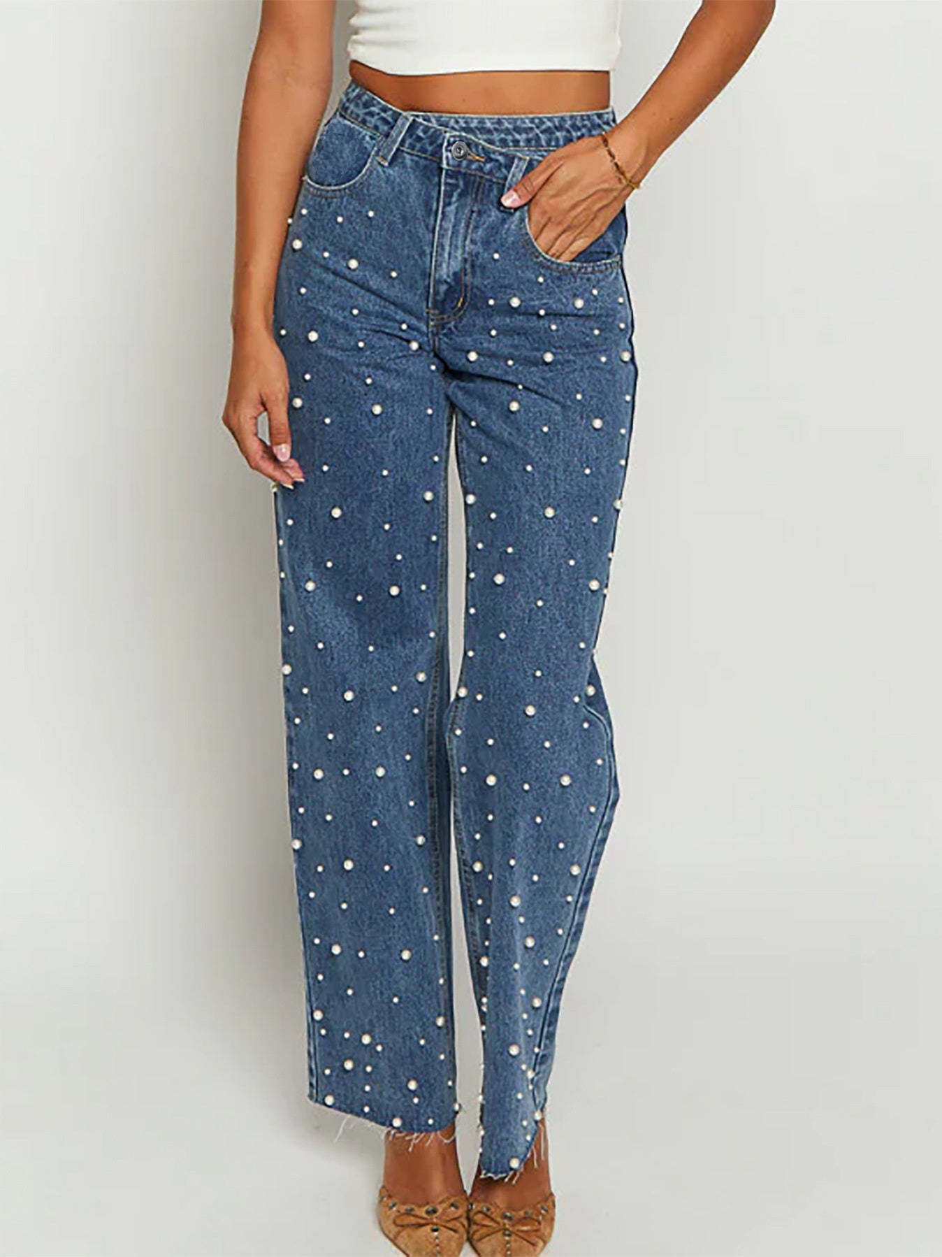 Jeans med skæv talje, krydsede perler og lige ben med flosset kant