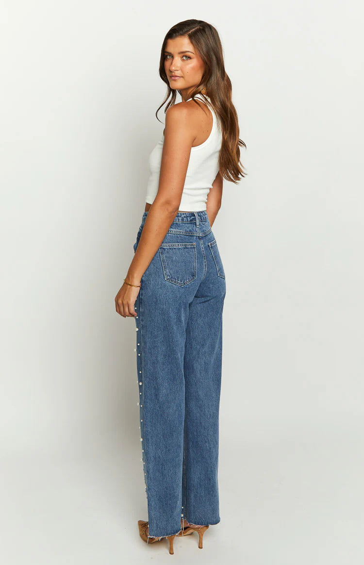 Jeans med skæv talje, krydsede perler og lige ben med flosset kant