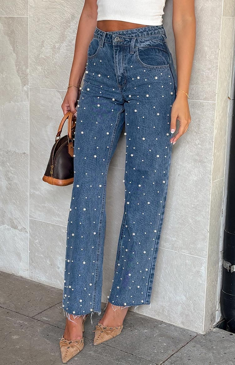 Jeans med skæv talje, krydsede perler og lige ben med flosset kant