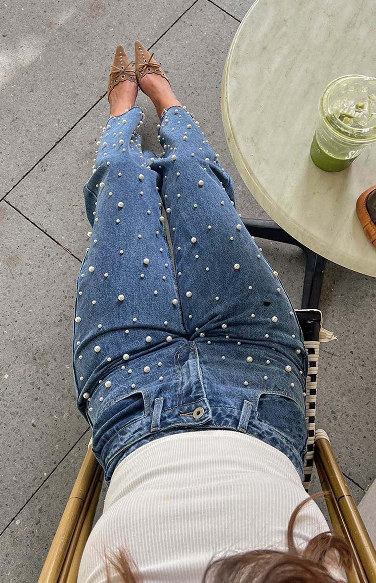 Jeans med skæv talje, krydsede perler og lige ben med flosset kant