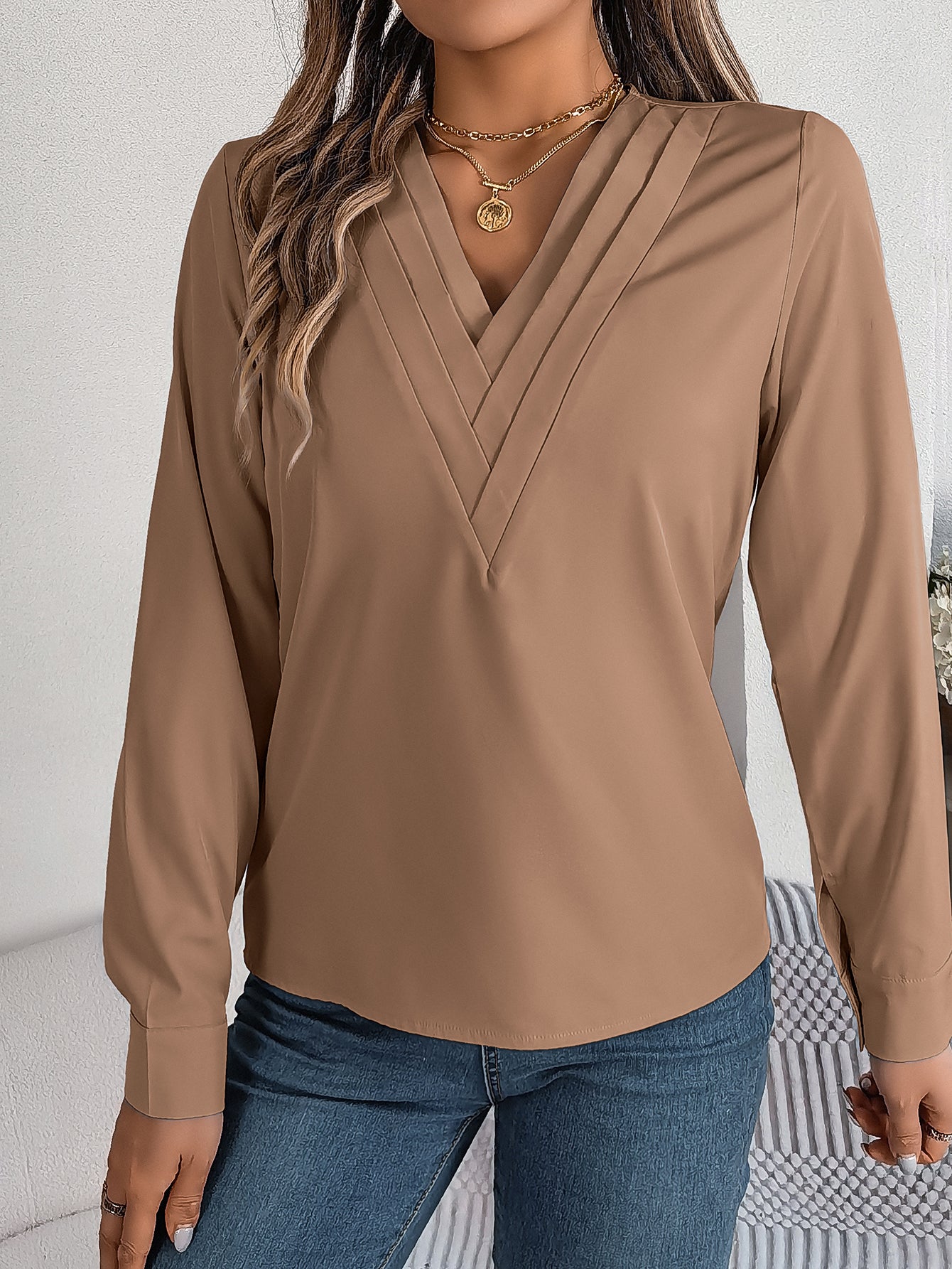 Elegant ensfarvet lagdelt V-halsbluse med lange ærmer