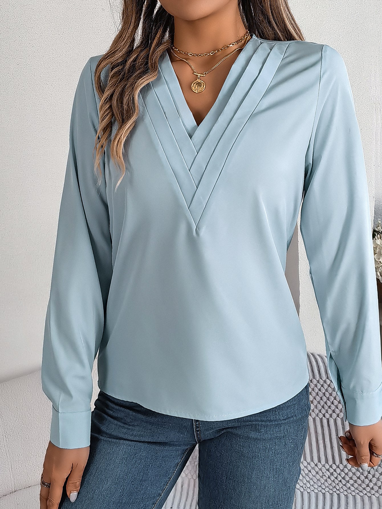 Elegant ensfarvet lagdelt V-halsbluse med lange ærmer