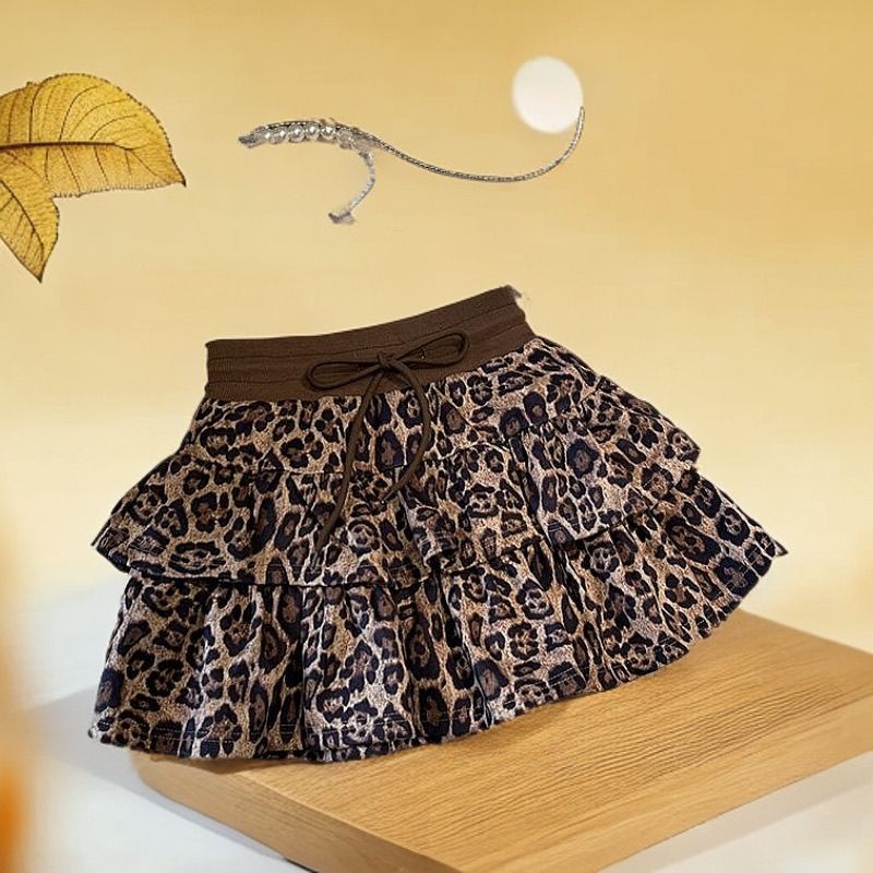 Plisseret nederdel med leopardprint og flæsekant, der modvirker blottelse