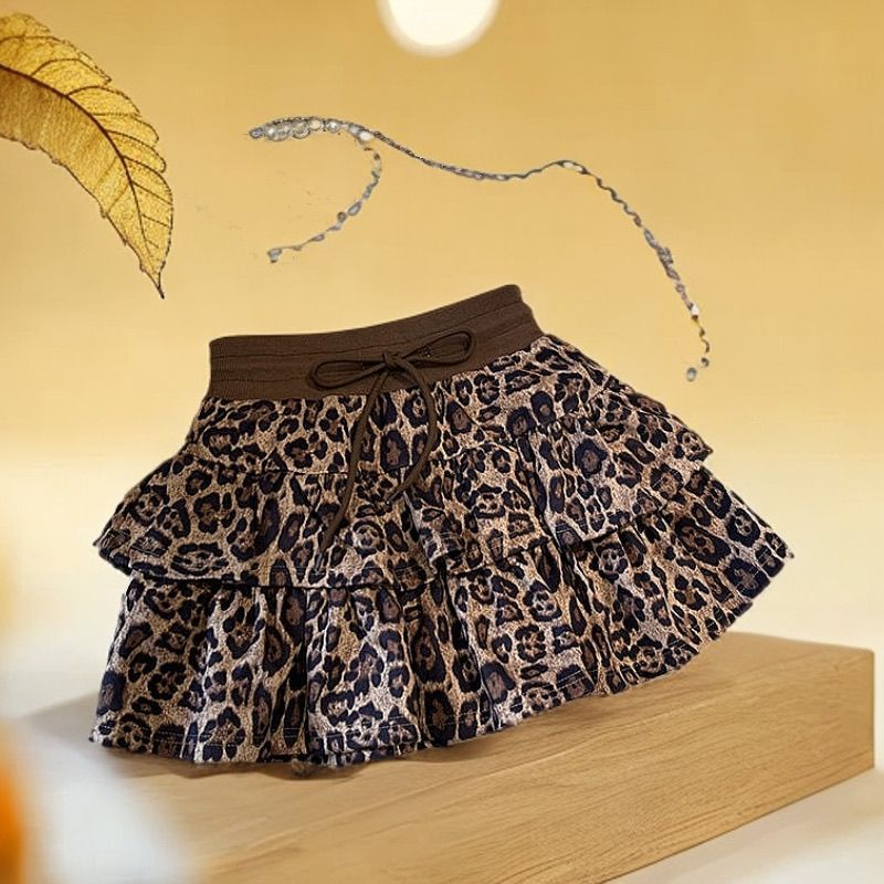 Plisseret nederdel med leopardprint og flæsekant, der modvirker blottelse